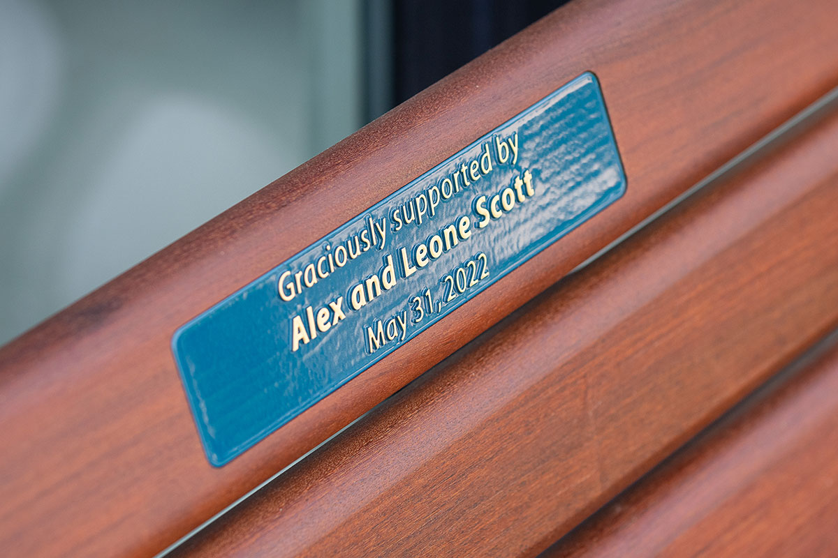Commemorative plaque mounted on a wooden park bench.