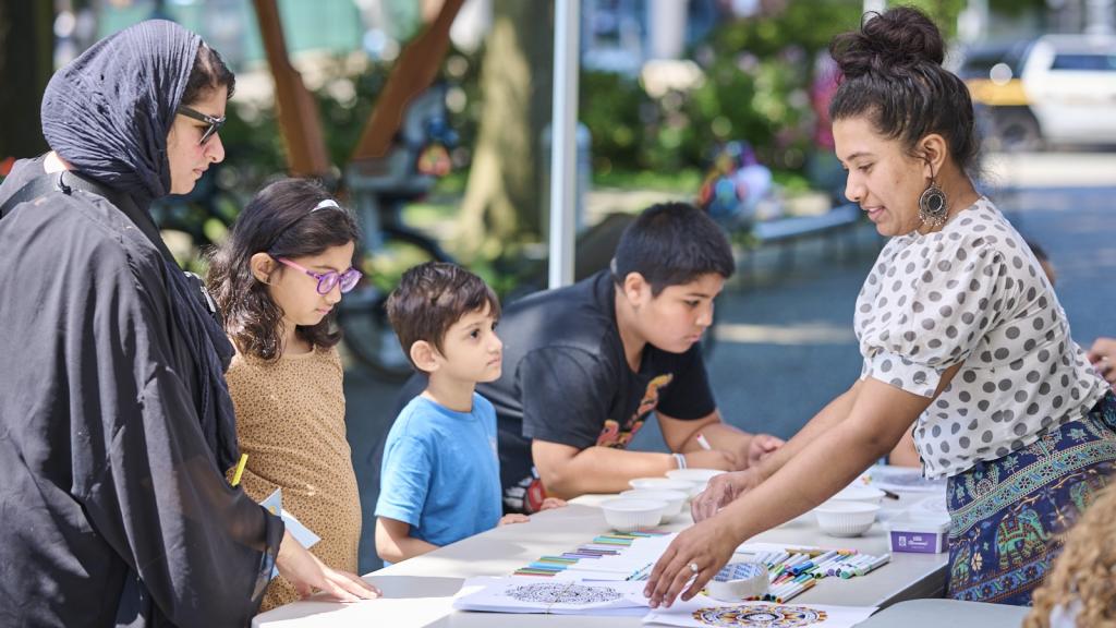 Artist Eisha Menon teaches the art of kolam outside the Clearbrook Library on July 6.