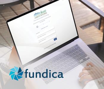 image of woman using a laptop, the website on display is the new City of Abbotsford and Fundica portal. 