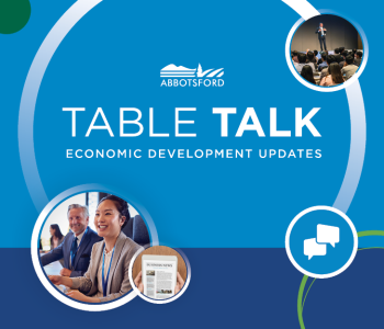 Graphic with a blue background featuring the City of Abbotsford logo above the large title “Table Talk” and subtitle “Economic Development Updates.” Circular photos show business professionals in a meeting, a speaker presenting to an audience, and a newspaper labeled “Business News,” with a speech bubble icon representing conversation.