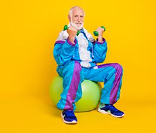 older man sitting on balance ball with weights